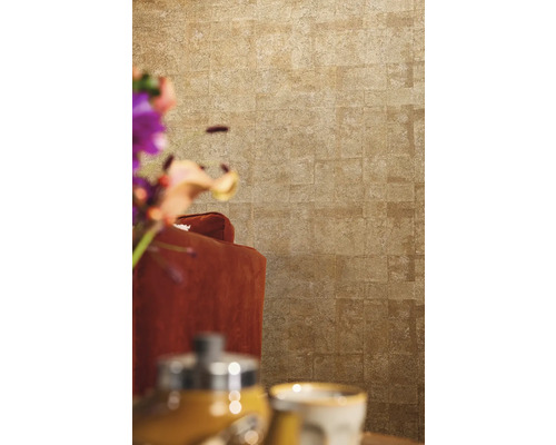 Close-up van een muur met steenlook behang achter een fauteuil.