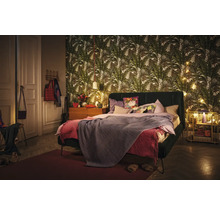 Slaapkamer met bed, nachtkastje en behang met print