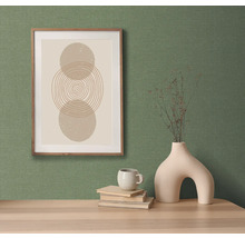 Decoratief stilleven met een afbeelding, een vaas en een kop op een tafel.