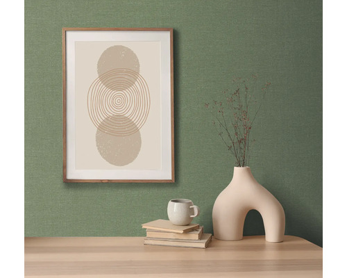 Decoratief stilleven met een afbeelding, een vaas en een kop op een tafel.