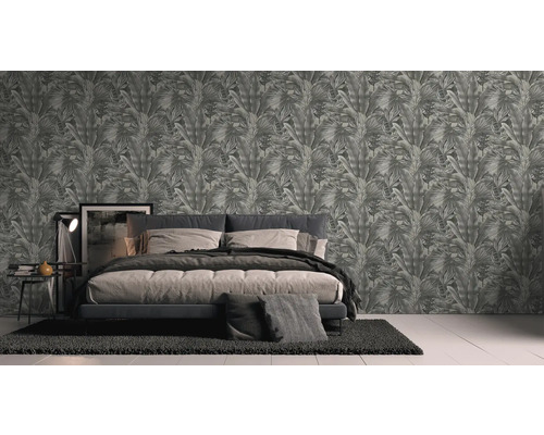 Slaapkamer met bed en behang met plantenmotief