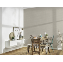 Eetkamer met houten tafel en stoelen voor een gestructureerde muur