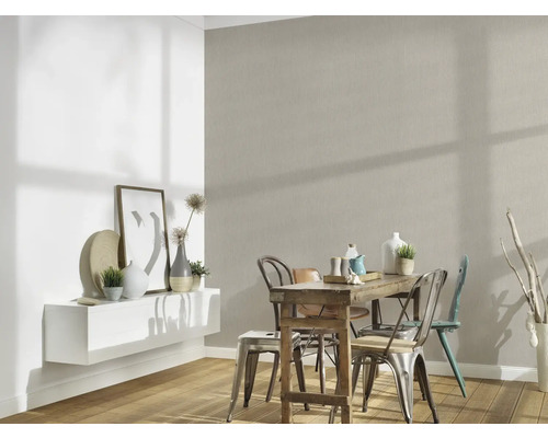 Eetkamer met houten tafel en stoelen voor een gestructureerde muur