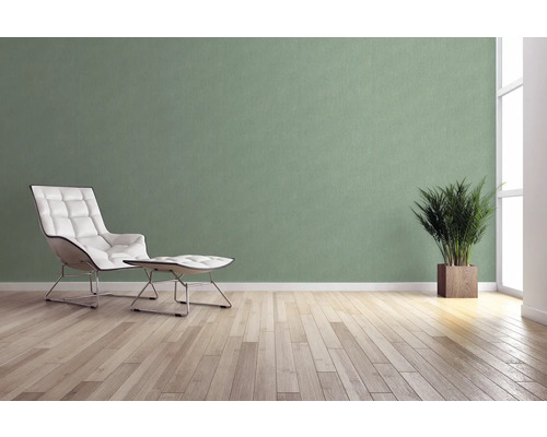 Lichte kamer met fauteuil, voetenbank, kamerplant en wandbekleding