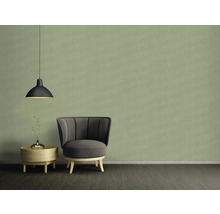 Woonkamer met fauteuil, bijzettafel en hanglamp voor een behang