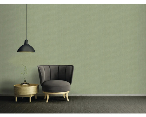 Woonkamer met fauteuil, bijzettafel en hanglamp voor een behang