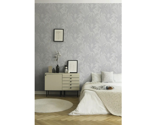 Lichte slaapkamer met patroonbehang, commode, bed en rond vloerkleed