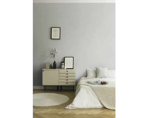 Slaapkamer met bed, commode, decoratie en vloerkleed op parketvloer