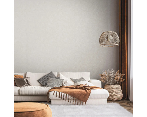 Woonkamer met bank, kussens, deken, lamp en decoratie in gezellig design.