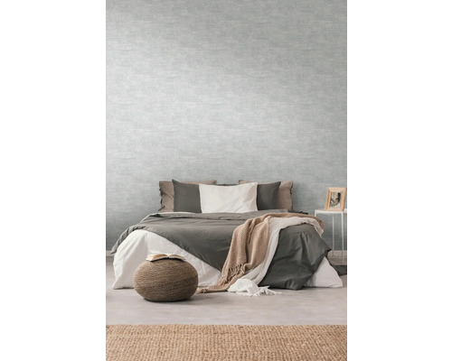 Slaapkamer met bed, nachtkastje en lichtgrijs behang