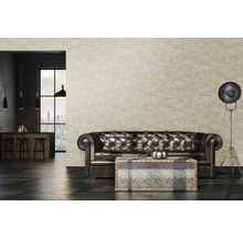 Woonkamer met leren bank, salontafel en vloerlamp voor een patroonbehang