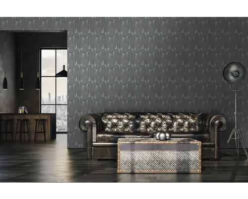 Interieur van een woonkamer met een grijs patroonbehang, een leren bank en een staande lamp