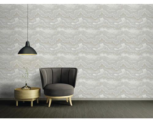 Woonkamer met fauteuil, bijzettafel en patroonbehang