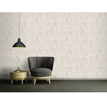 Woonkamer met fauteuil, bijzettafel, hanglamp en behang met patroon