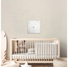 Babykamer met kinderbed en muurdecoratie met de tekst ''Little Explorer''.