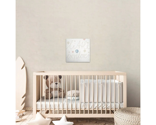 Babykamer met kinderbed en muurdecoratie met de tekst ''Little Explorer''.