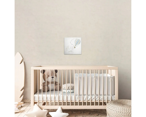 Kinderkamer met kinderbed, teddybeer en muurschildering met luchtballonmotief