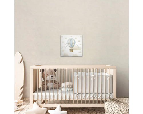 Kinderkamer met babybed, teddybeer en muurdecoratie met luchtballonmotief