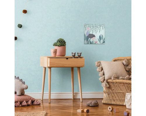 Decoratieve kinderkamerscène met houten bijzettafel, canvasprint, potplanten en rotan stoel