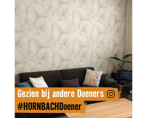 Woonkamer met bank en behang met bladerenmotief