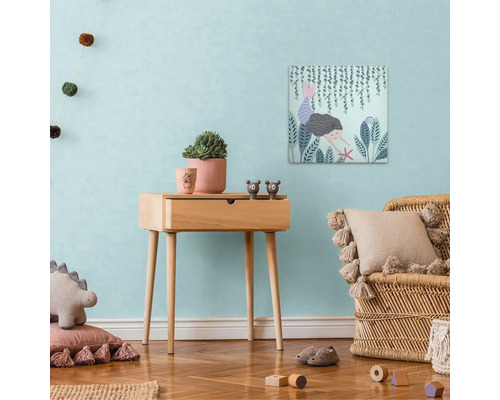 Kinderkamer met houten tafel, decoraties en muurschildering met zeemeerminthema.