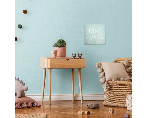 Decoratieve kinderkamer met houten bijzettafel, muurschildering en rotan stoel