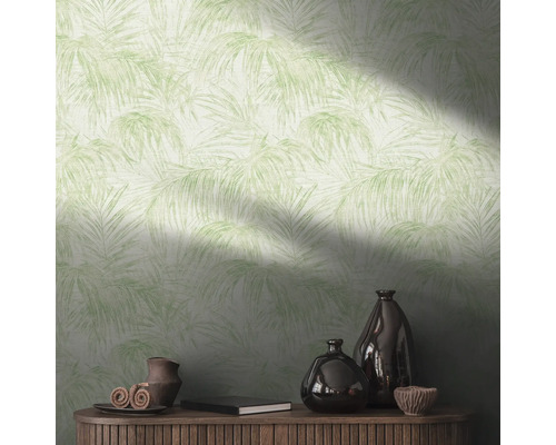 Wand met behang met palmmotief en decoratieartikelen op een houten kast