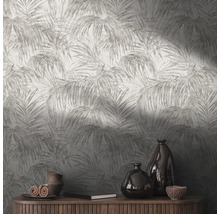 Close-up van een muur met palmenbladbehang en een houten dressoir met decoraties
