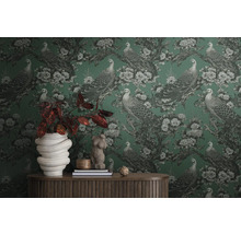 Kamer met behang met patroon van pauwen en bloemen, gedecoreerd met woonaccessoires op een houten tafel