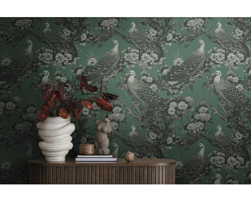 Kamer met behang met patroon van pauwen en bloemen, gedecoreerd met woonaccessoires op een houten tafel