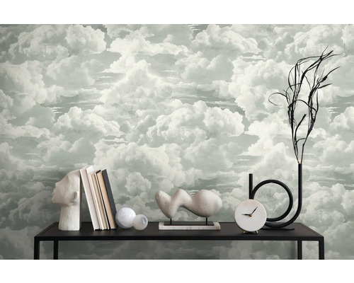 Interieurscène met wolkenbehang, boeken, decoraties en een klok op een zwarte tafel.