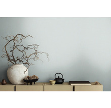 Decoratieve takken in vaas naast theepot op dressoir