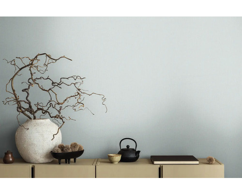 Decoratieve takken in vaas naast theepot op dressoir