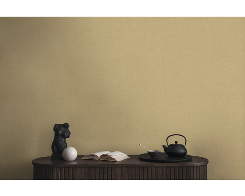 Decoratieve scène met een zwarte theepot, een beeld en een boek op een kast voor een wandbehang