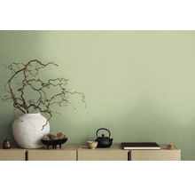 Decoratieve scène met vaas, takken, theepot en andere decoratieve elementen op een dressoir voor een wand