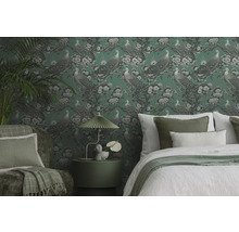 Decoratieve slaapkamer met behang met motief, bed, fauteuil en bijzettafel