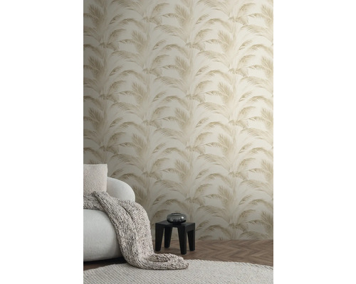 Woonkamer met behang met palmmotief, fauteuil, deken, vloerkleed en tafel
