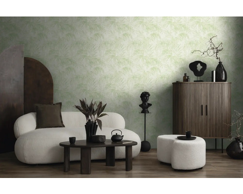 Woonkamer met behang met patroon, bank, kruk en donkere houten meubels.