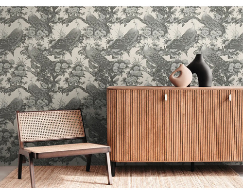 Decoratieve kamer met behang met pauwen en bloemen, een houten kast en een rotan stoel.