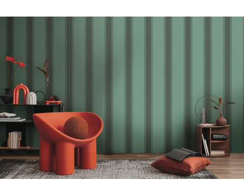 Gefeatureerde woonkamer met gestreept behang, fauteuil, vloerkleed en bijzettafel.