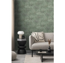 Woonkamer met bank, tafel en groen behang met bladeren