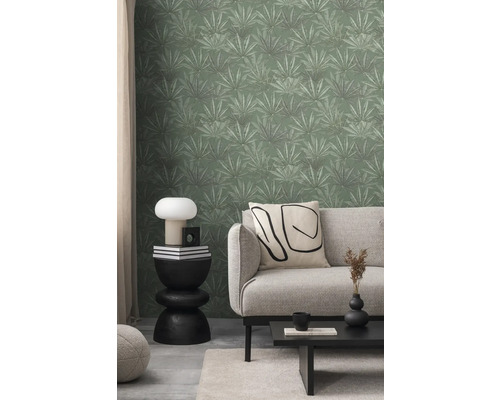 Woonkamer met bank, tafel en groen behang met bladeren