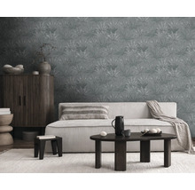 Woonkamer met bank, tafel, kast en behang met patroon.