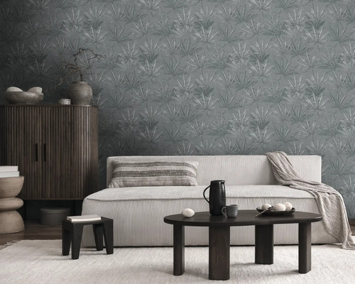 Woonkamer met bank, tafel, kast en behang met patroon.