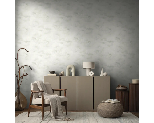 Inrichtingsvoorbeeld met een fauteuil, een kast en een behang met motief in een woonkamer.