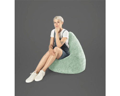 Vrouw zit op een druppelvormige zitzak van imitatiebont