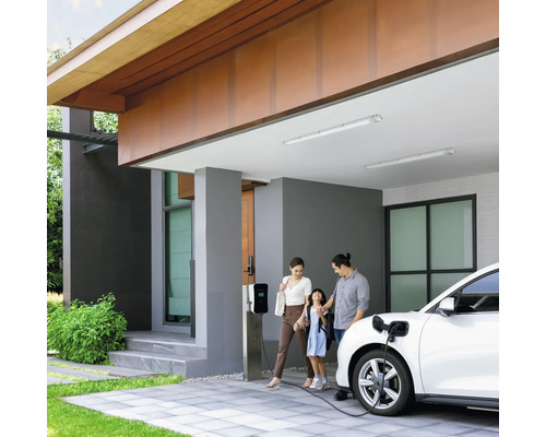Familie laadt elektrische auto op bij laadstation voor het huis