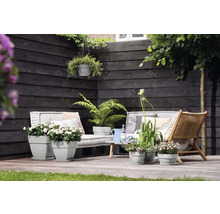 Terras met grijze plantenbakken, houten meubels en planten