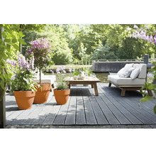 Terras met houten vlonder, meubels en beplante bloempotten