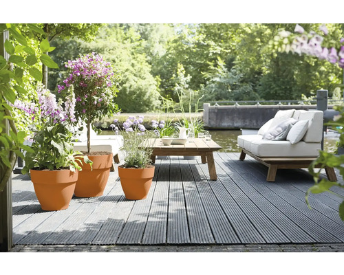 Terras met houten vlonder, meubels en beplante bloempotten